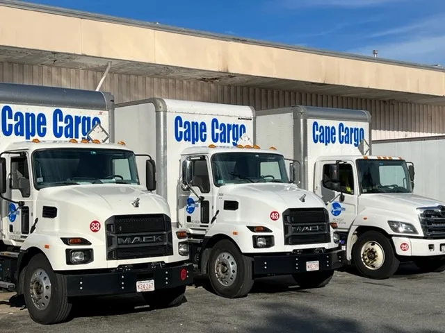 Row of white Cape Cargo trucks parked at a loading dock